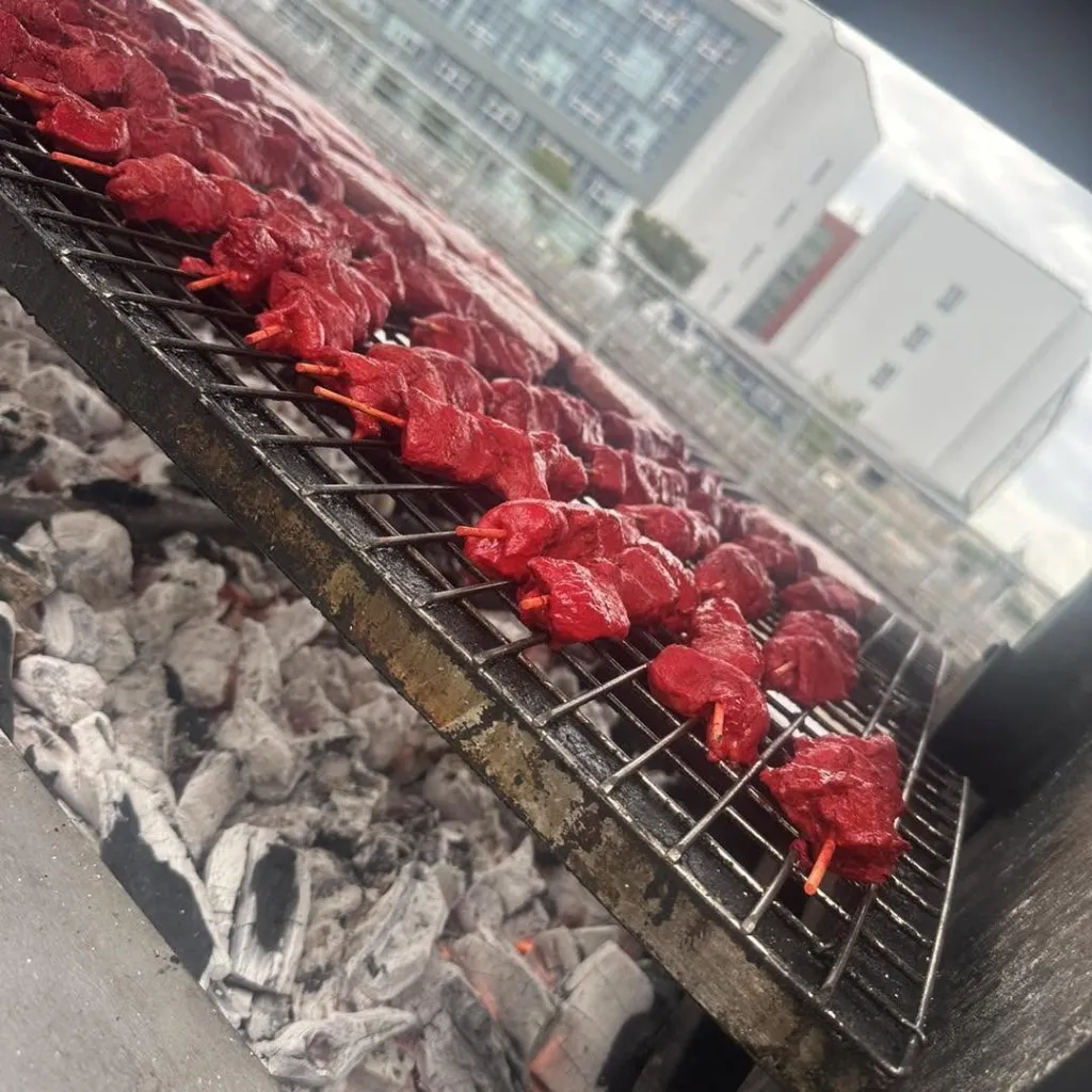 Marinated chicken kebabs cooking over charcoal