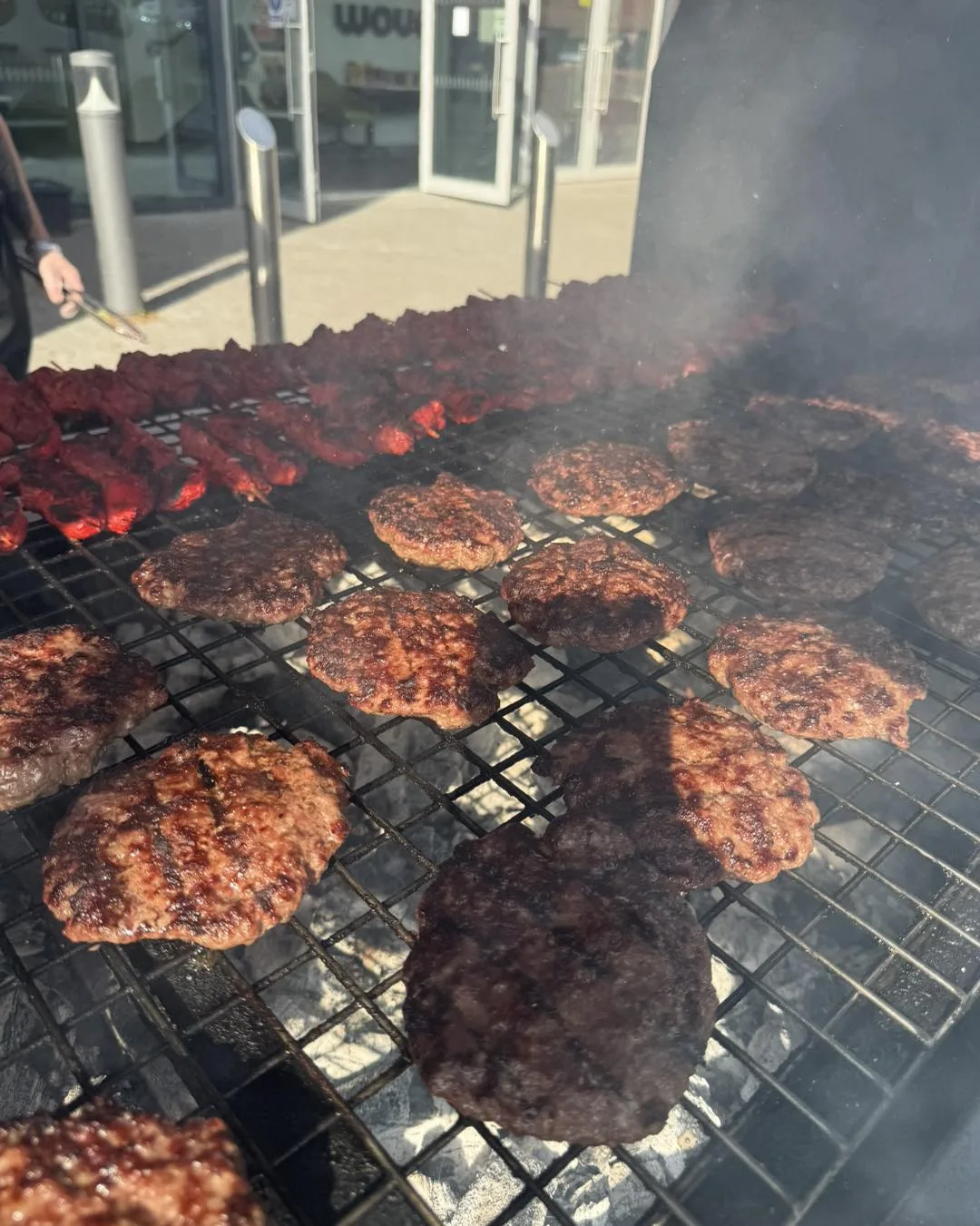 Burgers and meats on the BBQ grill with smoke