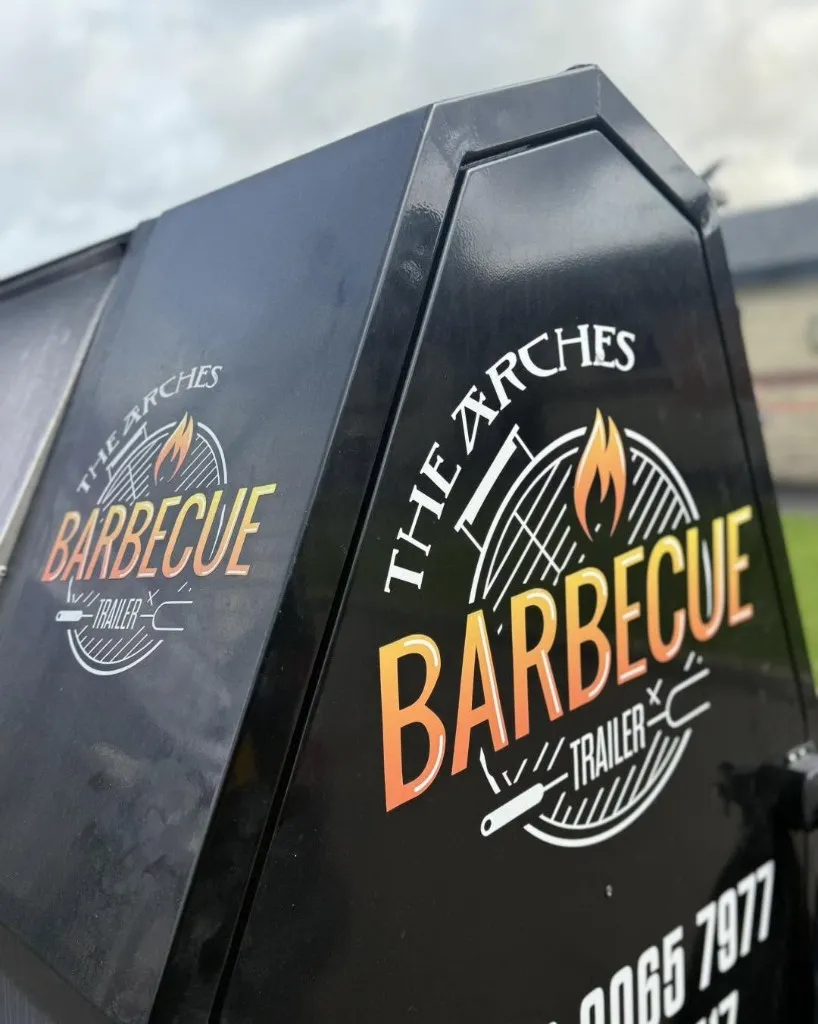Close-up of The Arches Barbecue Trailer branding